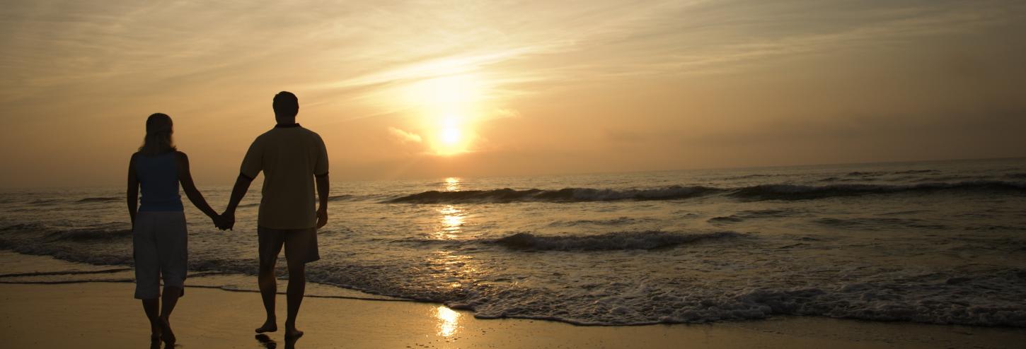 Couple walking the beach at sunset